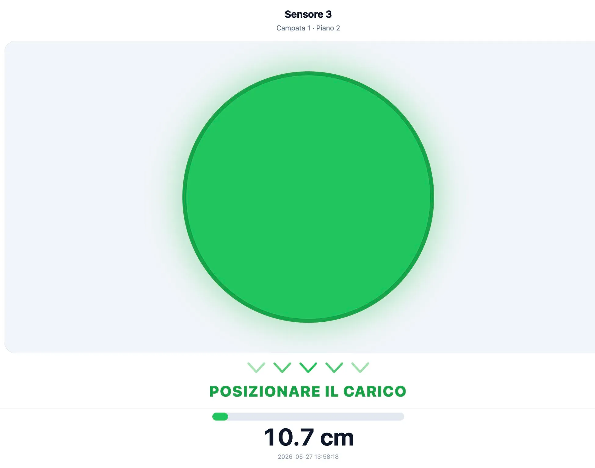 Schermata di guida al posizionamento: cerchio verde, scritta “POSIZIONARE IL CARICO” e distanza 10.7 cm